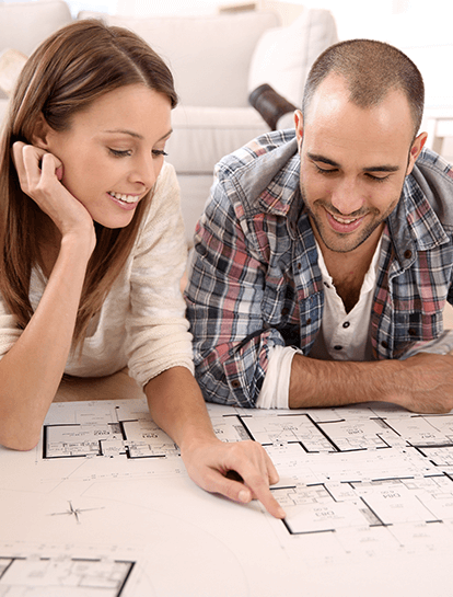 A couple review house plans and discuss construction loans