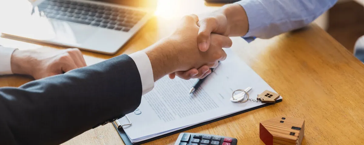 Shaking hands with a North Lakes mortgage broker after signing a contract
