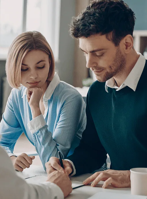 couple signing a document with a Wilston mortgage broker